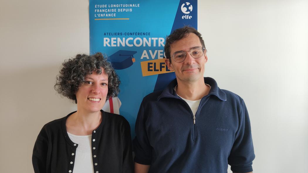 Iris Hourani et Thierry Siméon posent en souriant, devant une affiche de la cohorte Elfe